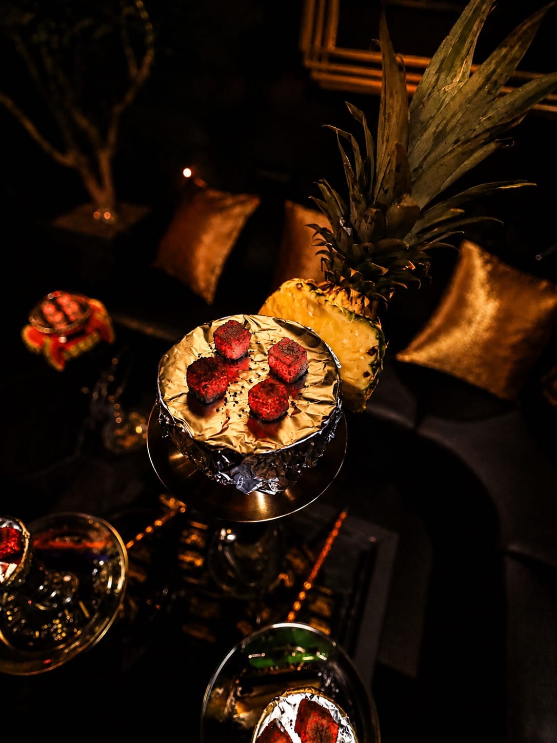 A pineapple and fresh fruit hookah bowl prepared with glowing coals