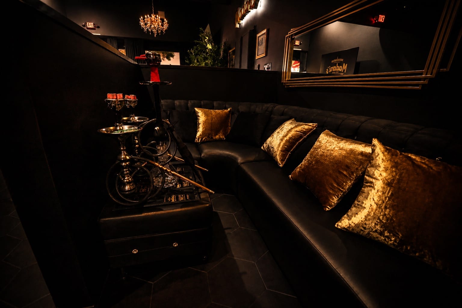 A private black leather booth with gold pillows inside Madani's